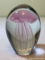 Front view of glass paperweight showcasing the detailed pink jellyfish encased within clear glass.