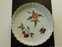 Top-down view of the Royal Worcester flan/tart dish showing the fruit pattern and gold rim detail.