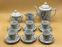 Photo showing the full tea set including teapot, creamer, sugar bowl, six cups and six saucers decorated with 11th Asian Games mascot PanPan.