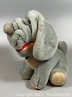 Side view of vintage Wrinkles plush dog showing gray plush material with beige nose, paws, and long floppy ears. Facial wrinkles and red mouth detail visible.