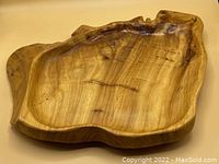 Top view of a natural wood live edge platter showing rich woodgrain and irregular edges with knotholes and natural cracks.