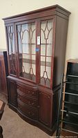Full view of antique wood grain buffet showing glass front doors with wood fretwork, curved drawers, and side cabinet doors