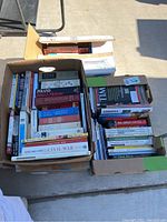Four boxes filled with a mix of books and magazines, showing titles and quantity