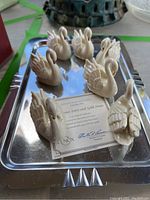 Set of seven ivory Lenox Golden Swan porcelain swan figurines with gold-tipped accents on a reflective silver-toned tray shown with Lenox certificate.
