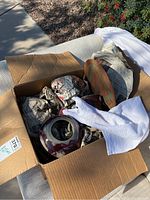 Box packed with various wrapped pottery items including plates and vases