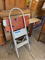 Aluminum step stool folded and standing upright showing two steps and rounded handle