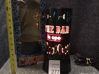 Photo showing the rotating bar light illuminated with the text 'THE BAR is open', box labeled 'Rotating Lamp' next to it, and a measuring tape indicating size approximately 12 inches.