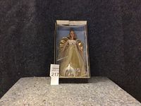 Front image showing new Barbie doll in its original packaging. Doll wears gold angel costume with wings and flowing dress.