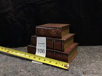 Photo of three stacked book look alike storage box drawers with a measuring tape showing length approximately 10 inches.