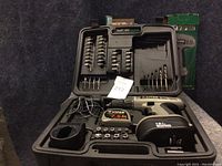 Viper 18V cordless drill kit in black plastic carrying case with assorted drill and screwdriver bits, battery, and charger, situated on carpeted surface.