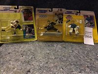 Front view of three NHL Starting Lineup sports figures in original yellow packaging showing a hockey player and two goalies.