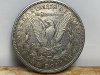 Reverse side of 1921 American Silver Dollar showing eagle with spread wings and inscriptions.