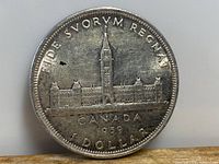 Reverse side of the 1939 Canadian silver dollar coin showing the Parliament buildings with inscriptions.