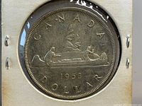 Reverse side of the 1953 Canadian Silver Dollar coin showing canoe with two figures and inscriptions 'CANADA' and 'DOLLAR 1953'.