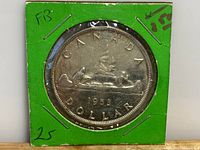 Front view of 1953 Canadian Silver Dollar coin showing reverse side with canoe and paddlers.