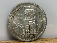 Obverse side of the 1958 Canadian silver dollar depicting a British Columbia indigenous totem pole and mountain scene with text 'CANADA 1858 1958 BRITISH COLUMBIA DOLLAR'