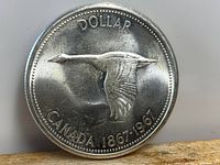 Obverse side of 1967 Canadian Silver Dollar showing flying Canada goose and inscription 'CANADA 1867-1967'.