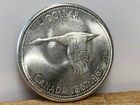 Obverse side of the coin showing a flying Canada goose with inscription '1 DOLLAR CANADA 1867-1967'.