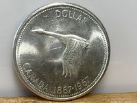 Obverse side of the coin featuring a flying Canada goose and inscriptions indicating a Centennial edition (1867-1967).