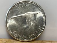 Obverse side of coin showing flying Canada goose and text 'DOLLAR CANADA 1867-1967'.