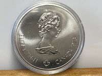 Obverse side of large 1976 Canadian silver Olympic coin showing Queen Elizabeth II, dated 1973.