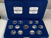 All thirteen coins displayed in blue velvet case interior
