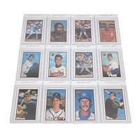 Top view of 12 vintage baseball cards in clear protective sleeves arranged in 4x3 grid showing players and signatures.