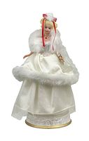 Front view of Barbie music box figure in white gown with fur trim and red ribbon in hair.