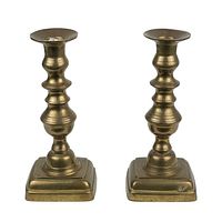 Photo of front view of two matching vintage brass candle holders showing shape and condition.