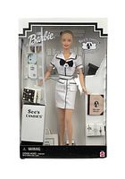 Front view of the Barbie doll in original See's Candies themed box showing doll in white and black uniform with candy boxes.