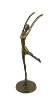 Front angle view of brass ballerina sculpture on round base showing arms raised and one leg backward.