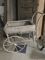 Side view of antique wicker flower cart showing woven basket, wooden spoked wheel, and tubular frame with handle