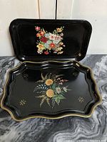 Both trays arranged to show size and decoration difference, floral motifs clear