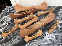 All nine birchbark canoe souvenirs displayed on a marble surface with visible stitching and natural birchbark texture