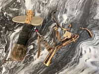 Overview of the vintage First Nations hunting tools and travel souvenirs on a marbled surface.
