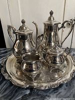 Full view of the complete five-piece silver plated coffee and tea set arranged on the tray.
