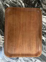 Top-down photo of vintage teak serving tray showing wood grain and rounded corners.