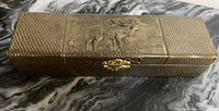 Top and front view of rectangular vintage metal box with textured and embossed elk design on the lid and decorative gold-tone clasp.