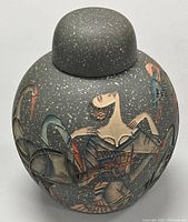Front view of the decorative jar showing the flapper woman and cranes design on the speckled grey ceramic body with matching rounded lid