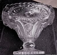 Side angle showing shape, pedestal base, and detailed cut patterns on crystal bowl.