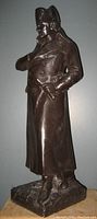 Side view of bronze-colored Napoleon Bonaparte statue showing detailed coat and hat.