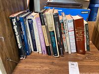 Photo showing the collection of 13 books arranged standing on a shelf including The Sports Immortals and Business Law Text and Cases