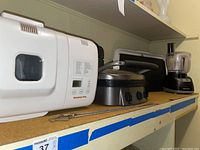 Wide side view of all four appliances on a kitchen shelf to show lot contents