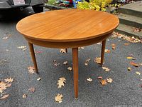 Full view of round teak table with all four legs attached