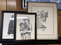 Three framed wall art pictures featuring mother and child sketches, two signed, placed in front of a window.