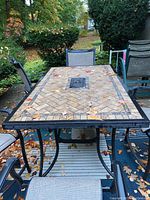 Top-down view of the full rectangular table on patio with leaf debris