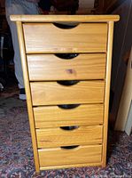 Front view of the 6 drawer wooden storage chest showing six drawers with cut-out handles and natural wood finish.