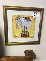 Front view of the framed cartoonish elephant standing on a decorated stand with bright yellow background.