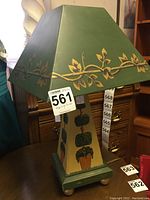 Full view of the wood lamp showing the base with topiary trees and the green metal shade with leaf decoration