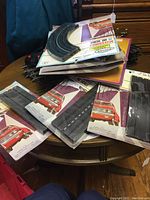 Pile of HO scale train track pieces, both loose and packaged, showing Aurora branded packaging with red car images.